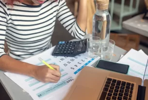 Microempreendedor individual sentado em frente ao computador, organizando finanças para a Declaração MEI 2025