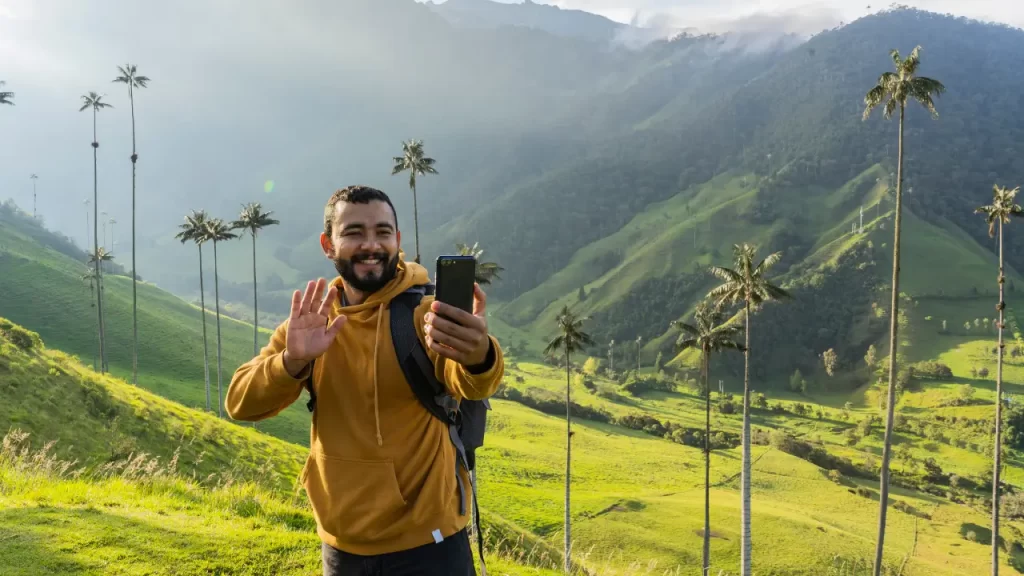 Viajante gravando vídeo para o TikTok em destino viral, com câmera e paisagem ao fundo