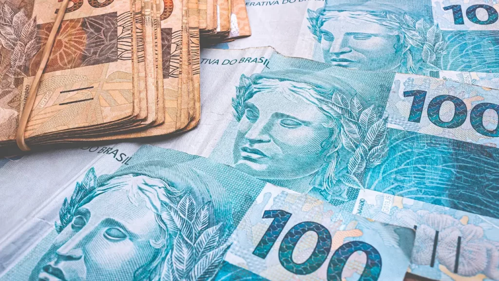 Cédulas de dinheiro indicando restituição IRPF 2025.