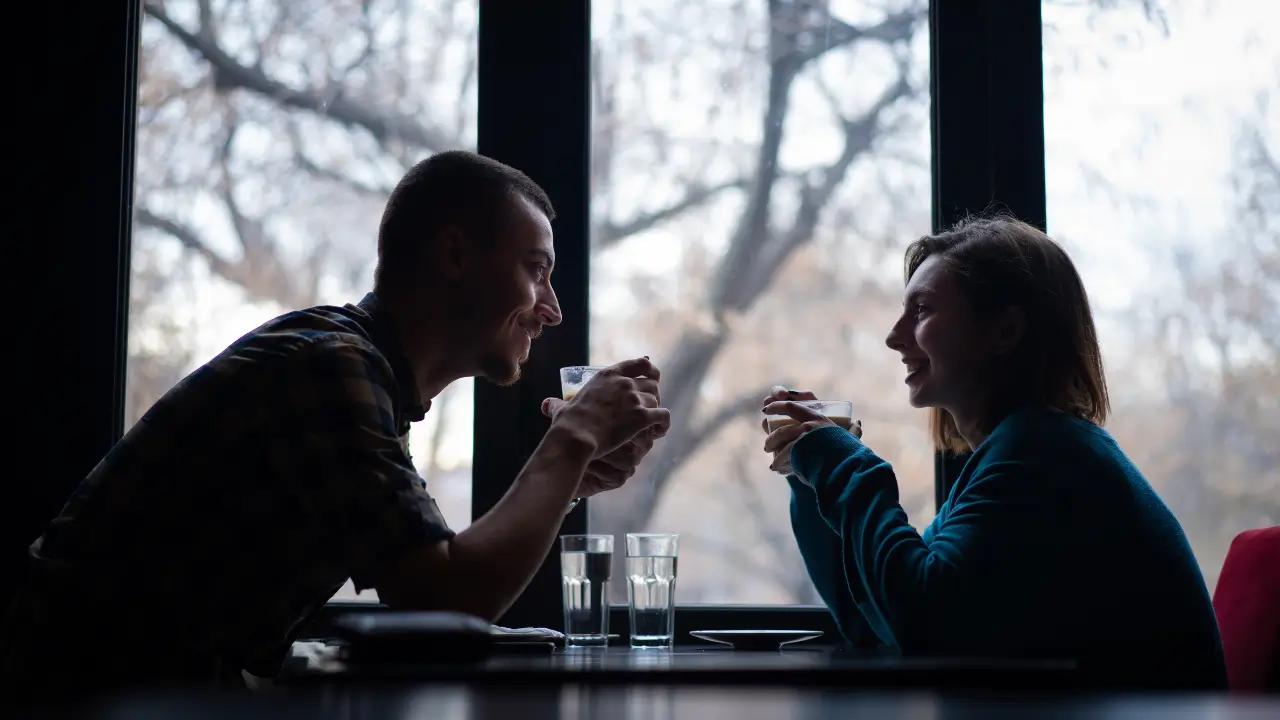 Casal sorrindo em café, representando sucesso nos apps de amor em 2025