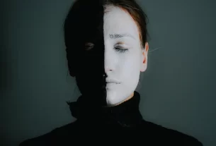 Ilustração de um rosto feminino dividido, metade iluminado e metade em sombra, representando o conceito da Sombra de Jung.