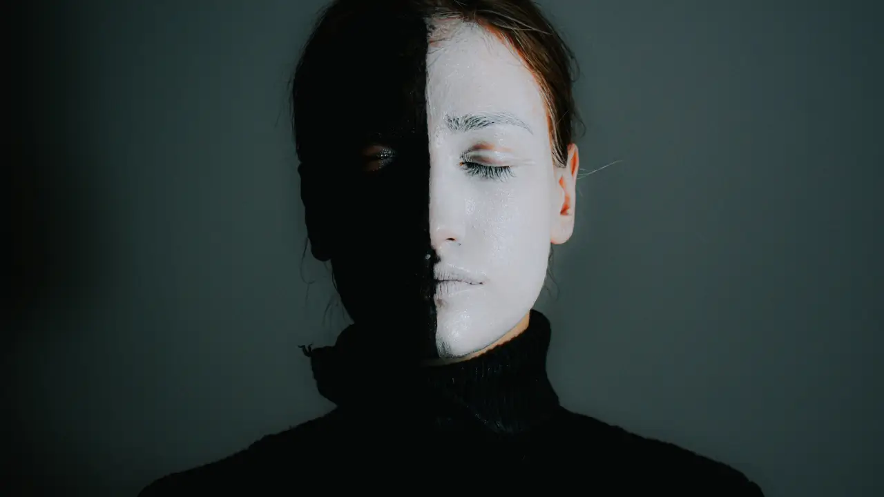 Ilustração de um rosto feminino dividido, metade iluminado e metade em sombra, representando o conceito da Sombra de Jung.