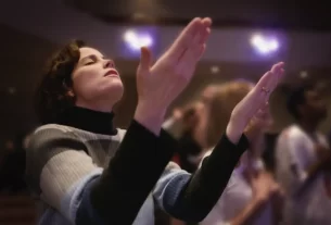 Pessoa ouvindo playlist devocional em culto, ideal para 2025.