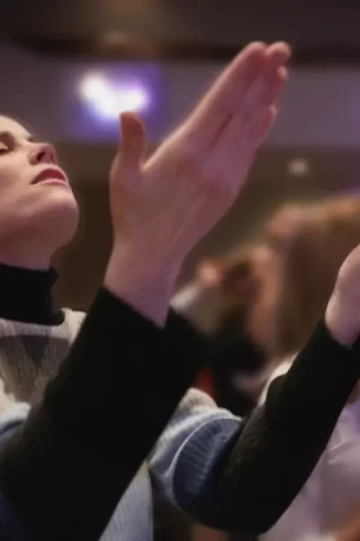 Pessoa ouvindo playlist devocional em culto, ideal para 2025.