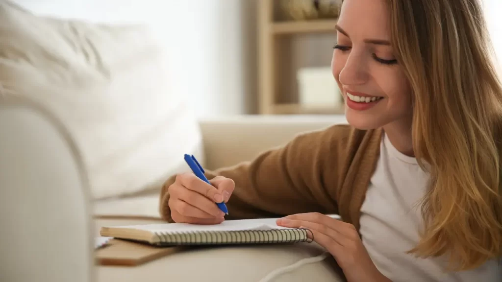 Pessoa sorrindo com caderno, mostrando os benefícios do Diário da Manhã para autoconhecimento.