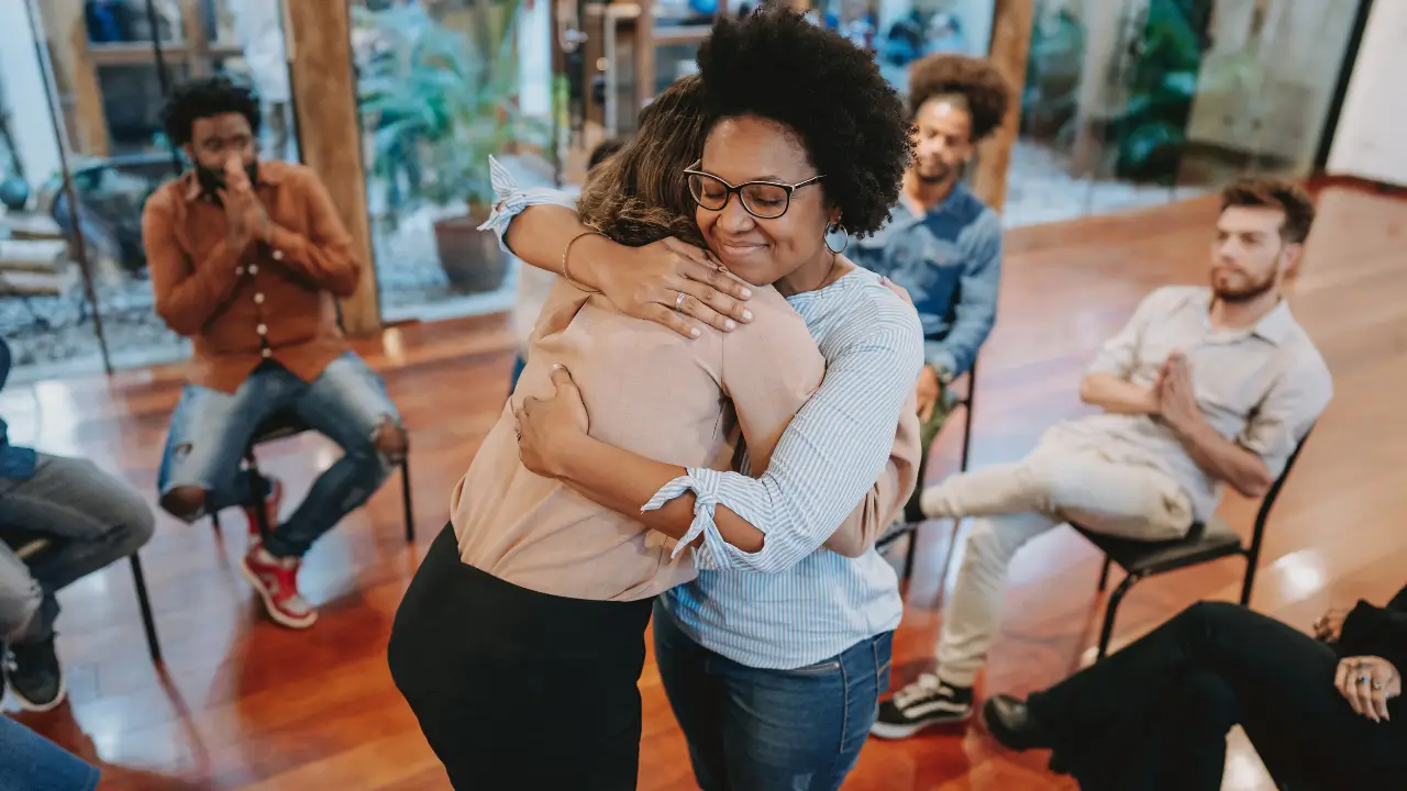 Duas pessoas se abraçando de forma genuína, representando a conexão após o trabalho com a Sombra.