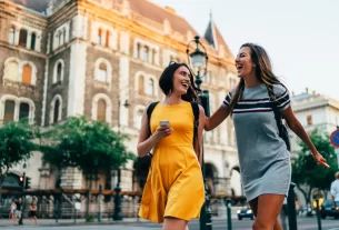 Mulheres felizes em praça em destinos subestimados na Europa