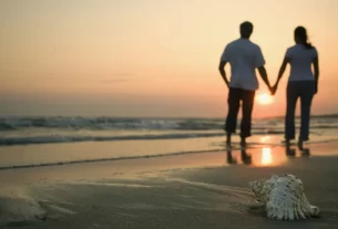 Casal de mãos dadas olhando para o horizonte, simbolizando um relacionamento com propósito e visão de futuro.