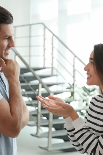 Um casal diverso sorrindo e conversando, ilustrando a comunicação para entender a linguagem secreta do seu parceiro.