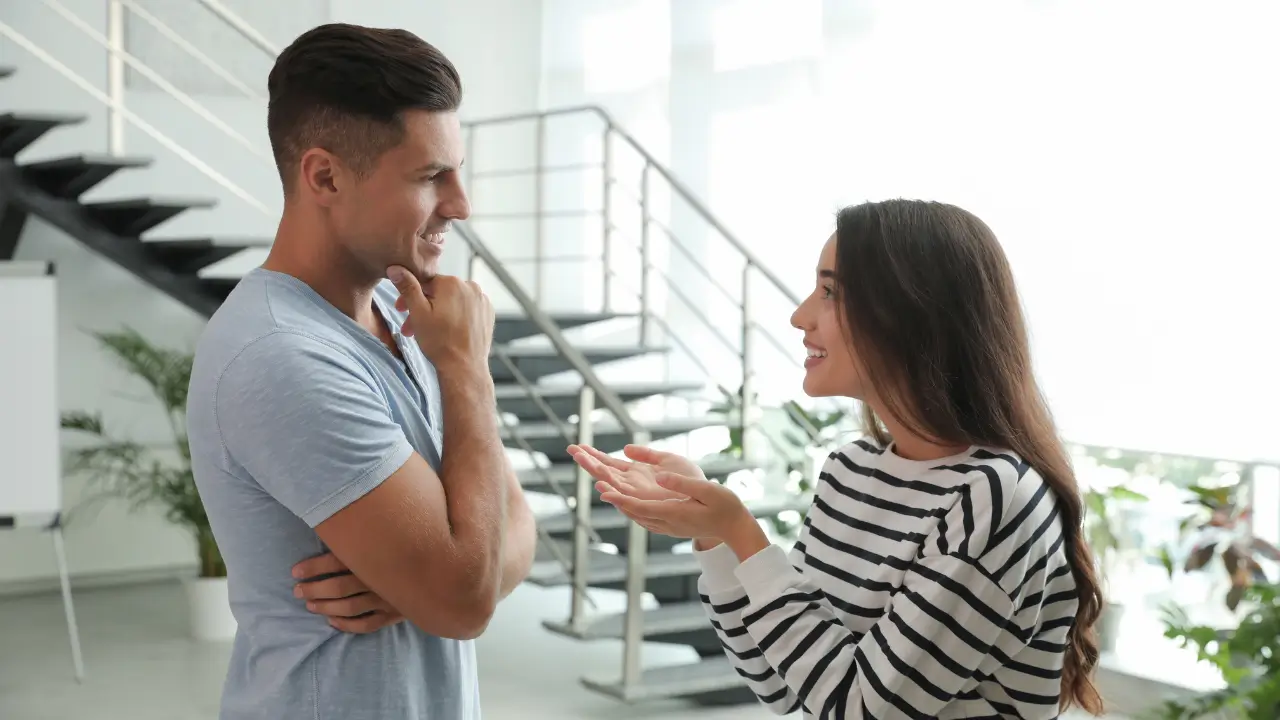 Um casal diverso sorrindo e conversando, ilustrando a comunicação para entender a linguagem secreta do seu parceiro.